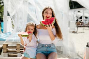 Happy cheerful little girl in white dress together with beautiful, sexy mom