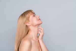 A profile shot of a woman looking up after neck liposuction