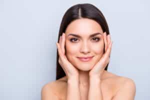 A woman touching her face after Dysport® injections in Miami