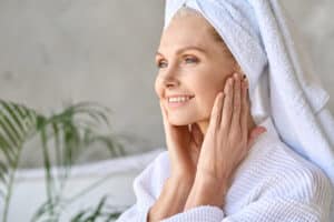 A woman looking in the mirror considering Perlane® for deep wrinkles