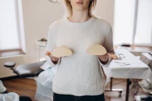 A woman holding breast implants in Miami